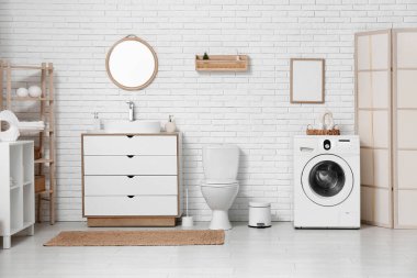 Tuvaletin içinde klozet, lavabo ve çamaşır makinesi var.