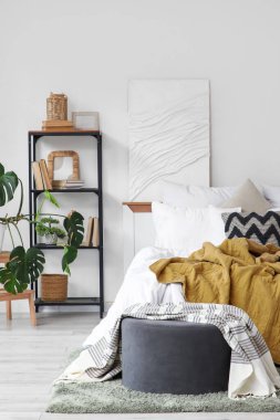 Kitap rafı, puf ve boyalı aydınlık yatak odasının içi