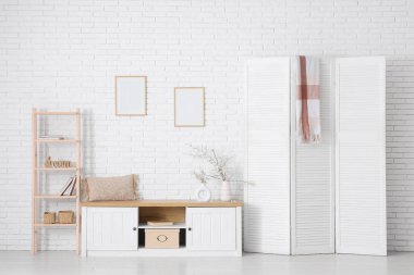 Kabinesinde katlanan ekran ve çiçek açan ağaç dalları olan şık bir odanın içinde.