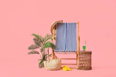 Çizgili iskemle, bir bardak kokteyl, plaj çantası ve pembe arka planda parmak arası terlik.