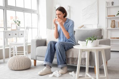 Dokuları evde hapşıran alerjisi olan genç bir kadın.