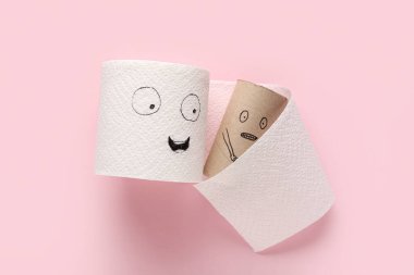 Tuvalet kağıdı rulosu ve pembe arka planda çizilmiş yüzleri olan boş karton tüp. Dostluk Günü kutlaması