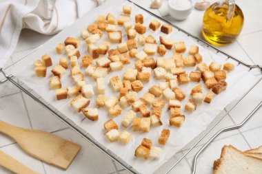 Beyaz karo zemin üzerinde çıtır çıtır çıtırlar olan fırın rafı, yakın plan.