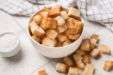 Beyaz fayans zemininde çıtır çıtır ve tuzlu kase, yakın plan.