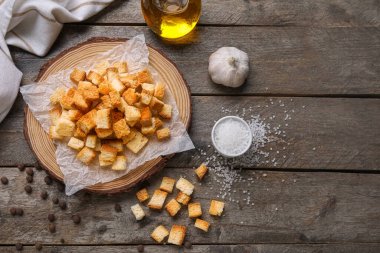 Tahtada kıtır kıtır ekmek ve ahşap arka planda farklı baharatlar var.