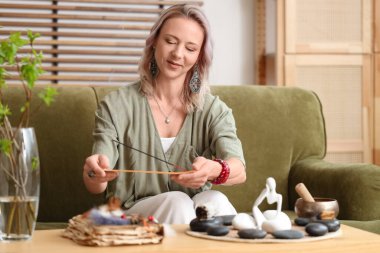 Evde tütsüsü yanan bir kadın.