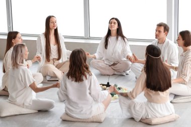 Daire içinde meditasyon yapan bir grup insan.