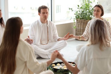Daire içinde meditasyon yapan bir grup insan.