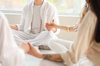 Daire içinde meditasyon yapan bir grup insan.