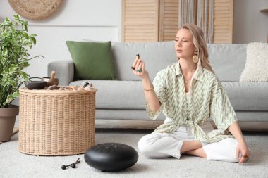 Kadın evde yanan Palo Santo ile meditasyon yapıyor.