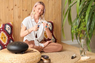 Kadın evde yanan Palo Santo ile meditasyon yapıyor.