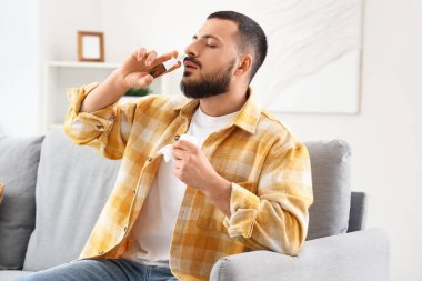 Evde alerji yüzünden burun damlası kullanan dokuları olan hasta genç bir adam.