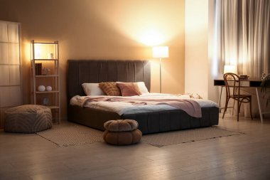 Rahat yatağı, yumuşak pufları ve geceleri parlayan lambaları olan şık bir oda.