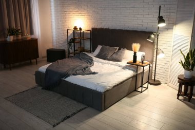 Yatak odasının iç dekorasyonu yumuşak yatak odası, raf ünitesi ve geceleri parlayan lamba.