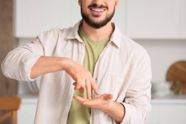 Evde işaret dili kullanan genç dilsiz adam.