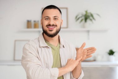 Evde işaret dili kullanan genç dilsiz adam.