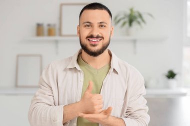 Evde işaret dili kullanan genç dilsiz adam.