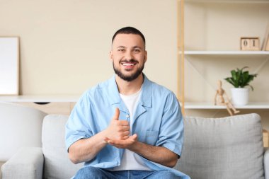 Evde işaret dili kullanan genç dilsiz adam.