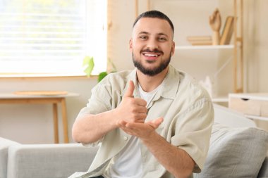 Evde işaret dili kullanan genç dilsiz adam.