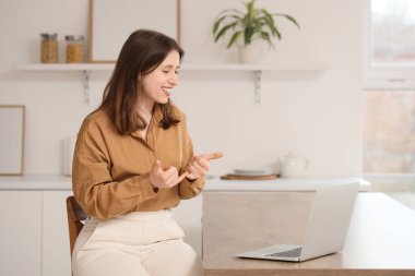 Evdeki video görüşmesi sırasında işaret dili kullanan genç dilsiz kadın.