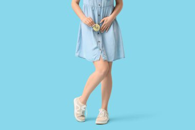 Mavi arka planda hüzünlü ifadeleri olan genç bir kadın. Sistit kavramı