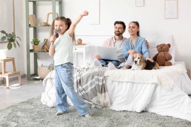 Ailesiyle küçük şirin bir kız ve yatak odasında karaoke yapan Beagle köpeği.