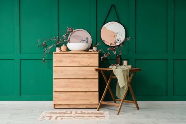 Lavabosu, çiçek açan dalları ve masası olan bir banyo.