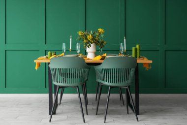 Gözlüklü, yanan mumlu ve çiçek açan ağaç dallı zarif bir masa.