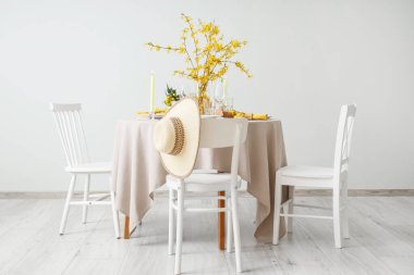 Yanan mumlar, bardaklar ve çiçek açan ağaç dalları olan zarif bir masa.