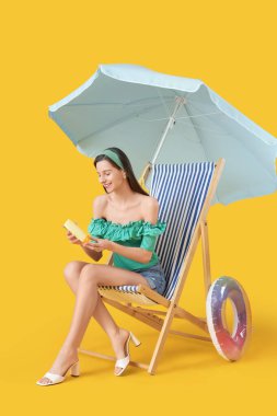 Sarı arka planda güneş kremi sürmüş genç bir kadın.