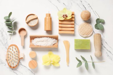 Farklı kozmetik ürünleri, spa aksesuarları ve açık arkaplanda orkide çiçekleri içeren kompozisyon