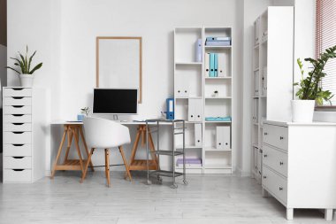 Doktorun çalışma yeri ve raf üniteleri olan bir tıp bürosu.