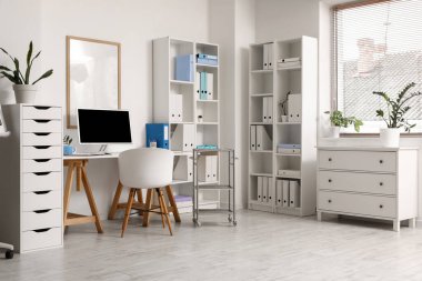 Doktorun çalışma yeri ve raf üniteleri olan bir tıp bürosu.