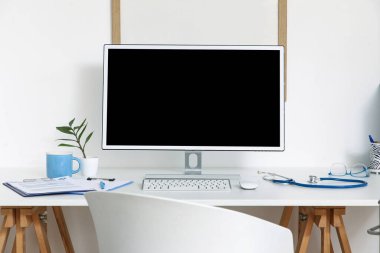 Tıp bürosunda boş bilgisayar monitörü olan bir doktorun işyeri.