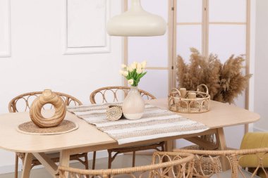 Yemek odasının içinde masa, katlanan ekran ve otlar var.