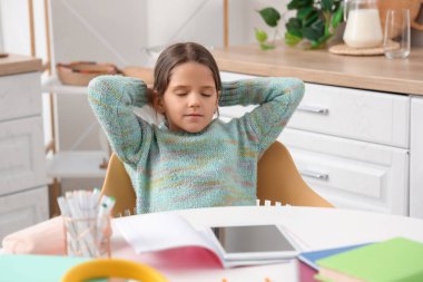 Mutfakta ders çalışırken tatlı kız dinleniyor.