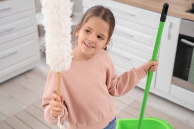 Mutfakta paspas ve toz bezi olan tatlı bir kız.