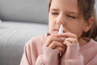 Evde burun damlası kullanan alerjik kız, yakın plan.