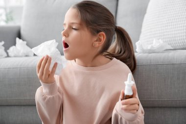 Doku ve burun damlası olan alerjik bir kız evde hapşırıyor, yakın plan.