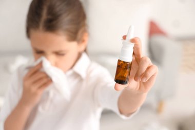 Evinde hapşıran burun damlası olan alerjik kız, yakın plan.