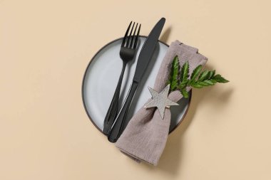 Siyah çatal bıçak takımı ve sarı arka planda taze yaprak ile güzel bir masa.