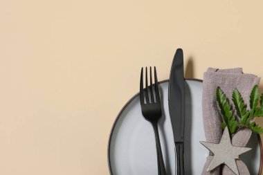 Siyah çatal bıçak takımı ve sarı arka planda taze yaprak ile güzel bir masa.