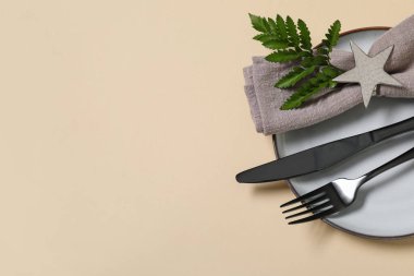 Siyah çatal bıçak takımı ve sarı arka planda taze yaprak ile güzel bir masa, yakın plan.