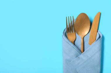 Mavi arka planda şık altın çatal bıçak takımı