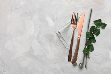 Gri arkaplanda paslanmaz çatal bıçak ve ağaç dalları