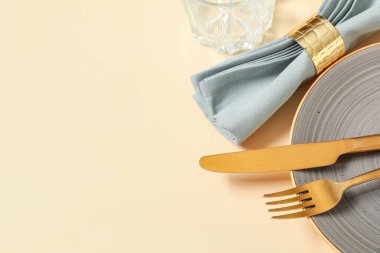 Sarı arka planda altın çatal bıçak seti olan güzel bir masa, yakın plan.