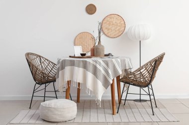 Yemek masası, lamba ve puf olan ışık odasının içinde.