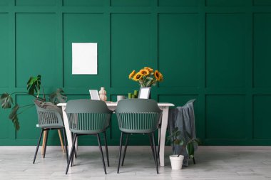 Yemek masası olan bir oda, vazoda ayçiçekleri ve bitkiler.