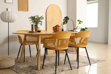 Yemek masası, lamba ve palmiye bitkileriyle ışık odasının içinde.