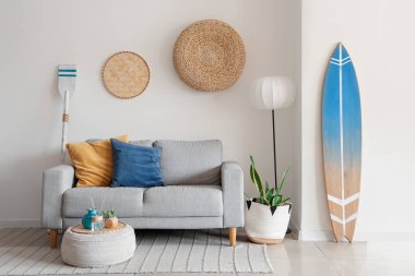 Gri kanepeli, puf ve sörf tahtalı şık bir oturma odası.